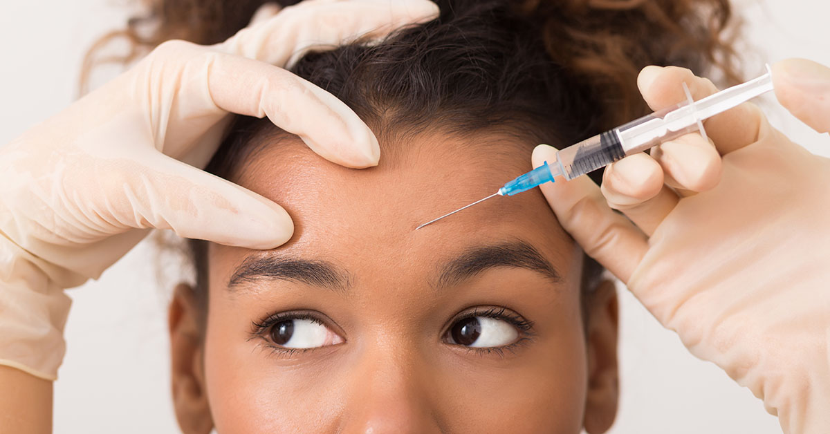 Cosmetic procedures. African-american woman getting botox injection in forehead; blog: Botox for Pain Relief: How it Works